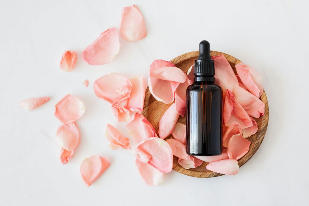 pexels-photo-4041392-4041392 Top view of empty brown bottle for skin care product placed on wooden plate with fresh pink rose petals on white background isolated